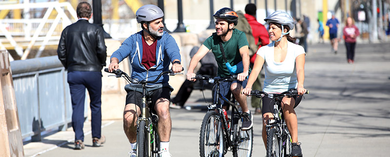 Two men and one woman bicycle riding 