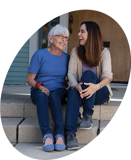Older woman and young woman sitting on steps laughing